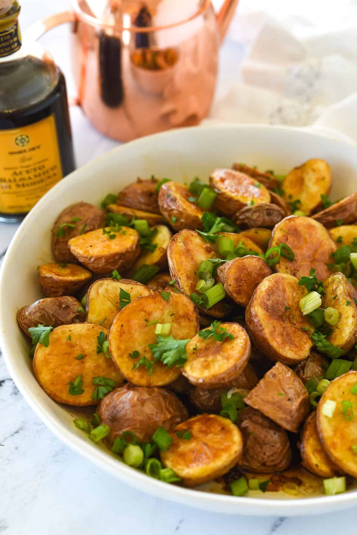 roasted balsamic potatoes iin a white bowl with parsley on top