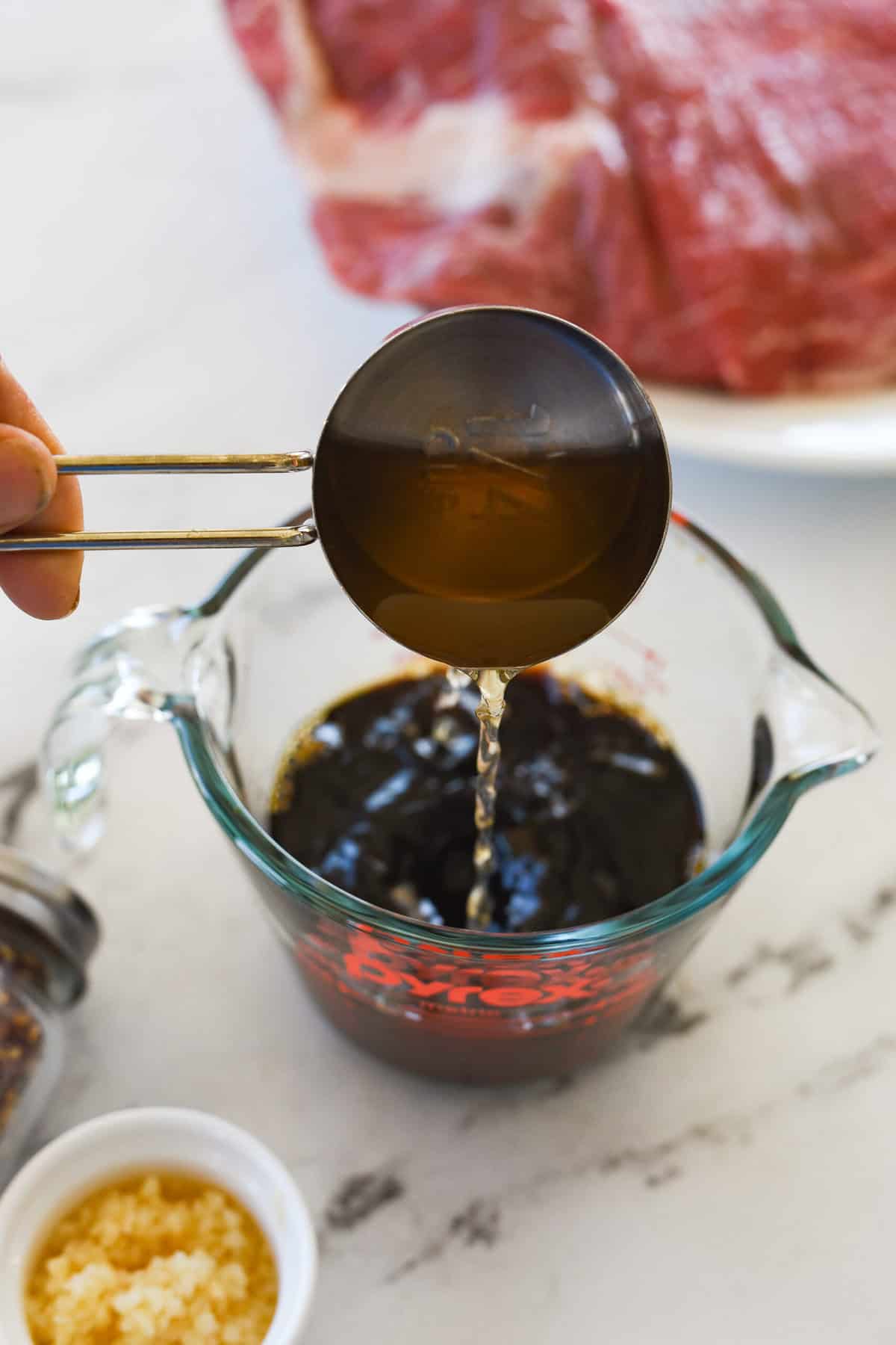 pouring vinegar into flan steak marinade
