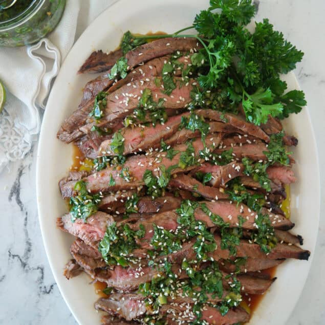 overhead shot of flank steak with chimchurrir sauce on it
