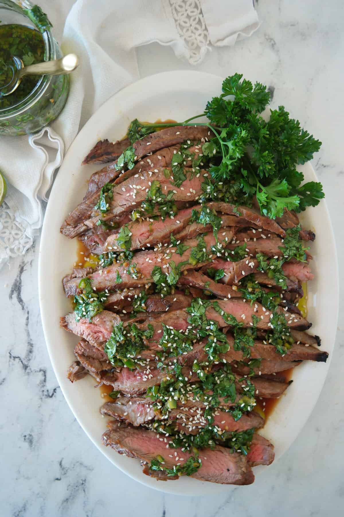 overhead shot of flank steak with chimchurrir sauce on it
