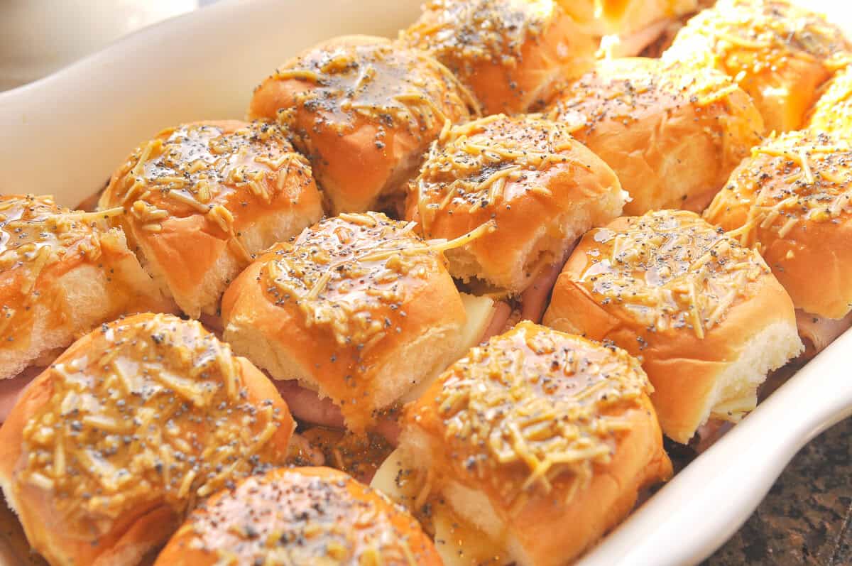 ha and cheese sliders with cheese and poppy seeds on top