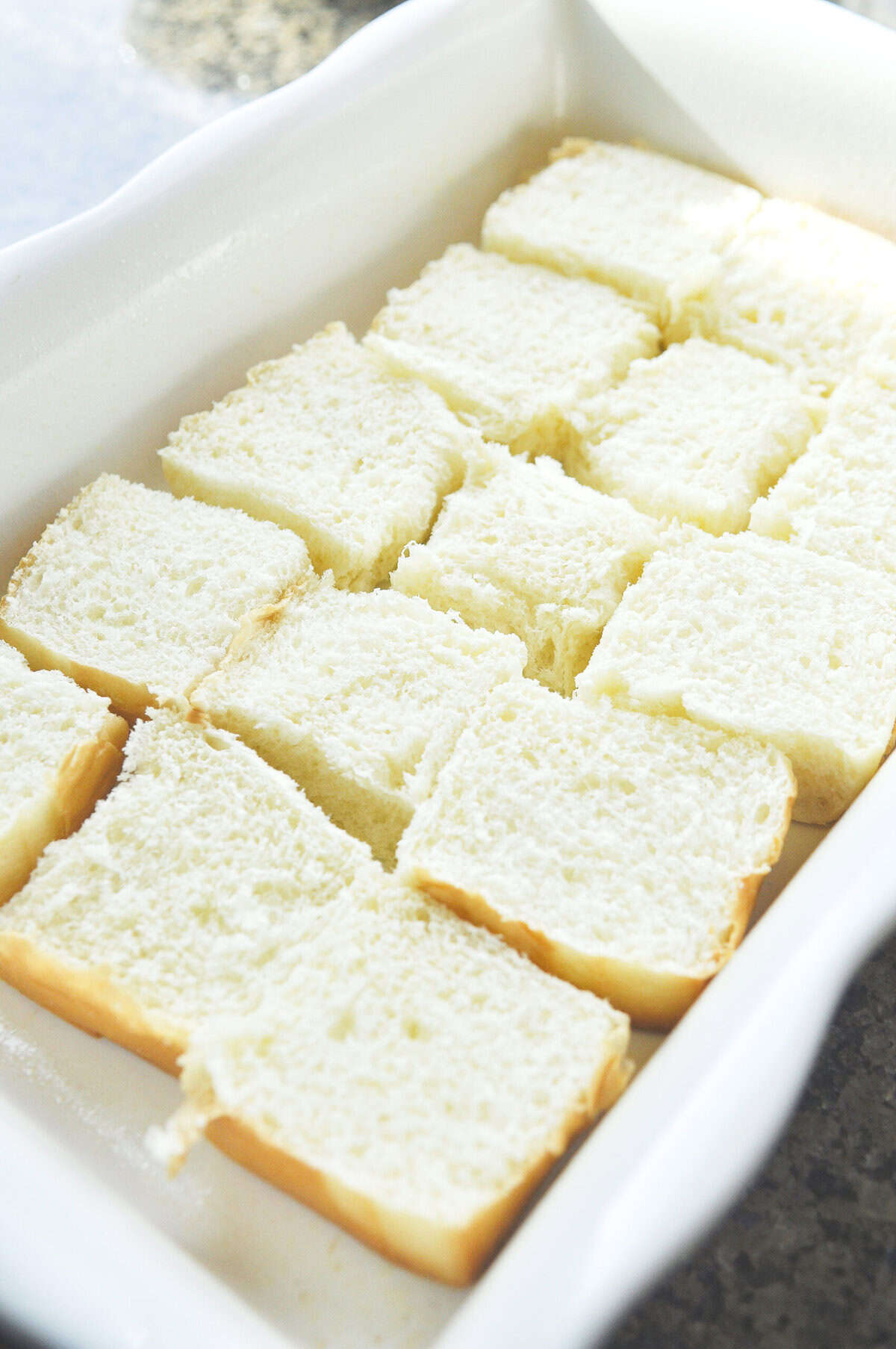 hawaiian rolls lined up in a baking dish, cut open