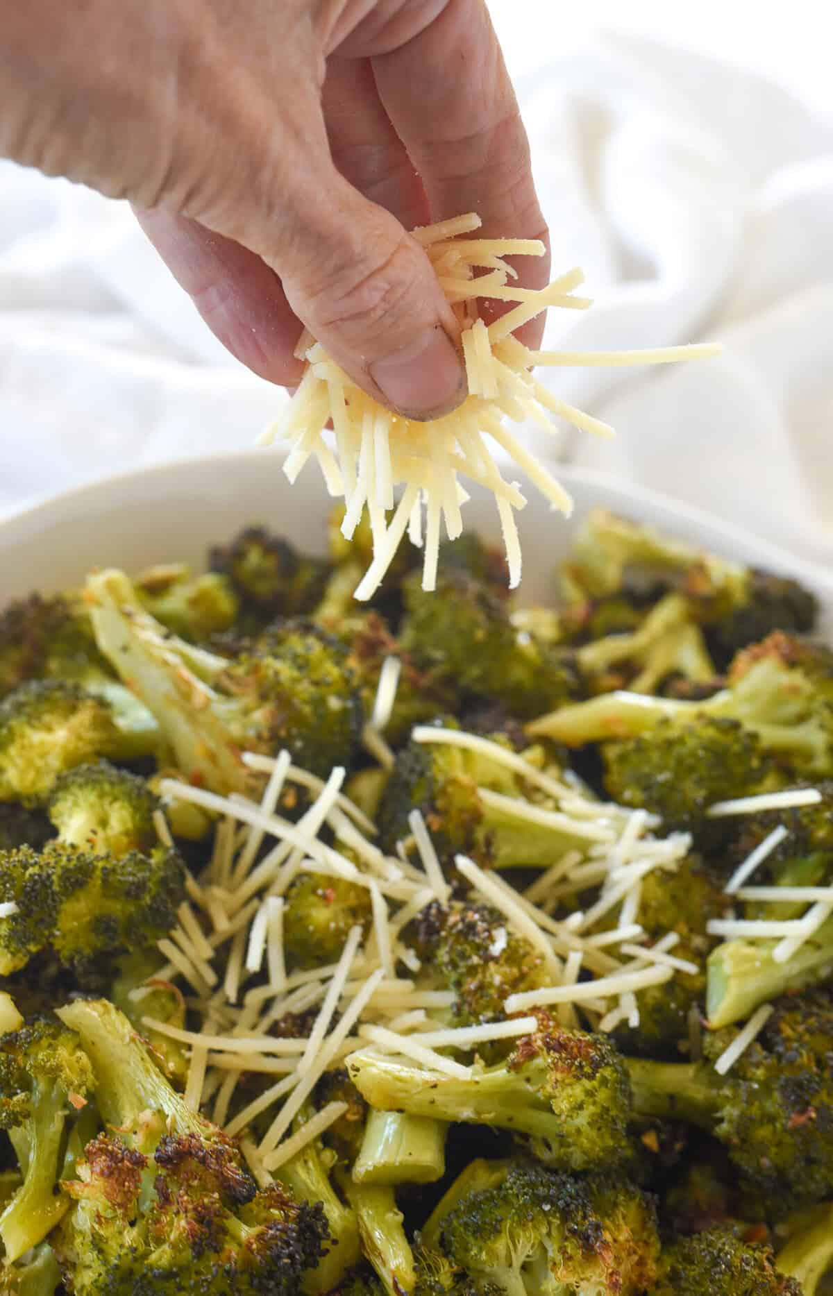 sprinkling broccoli with parmesan cheese