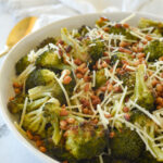 white bowl full of roasted broccoli with parmesan cheese on top