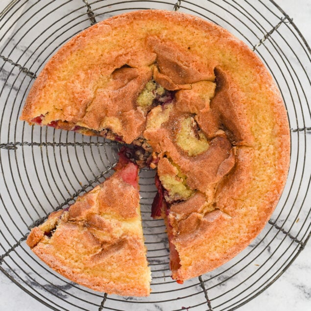 overhead shot of plum cake with a piece cut out of it