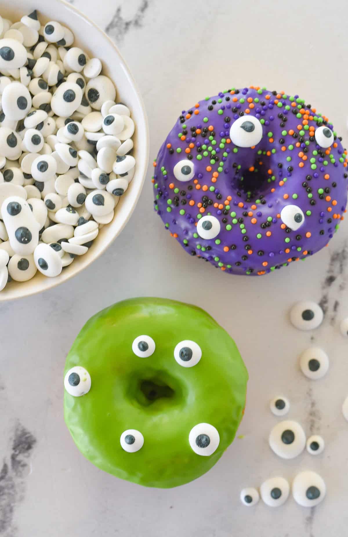 two donuts with candy eyes on them