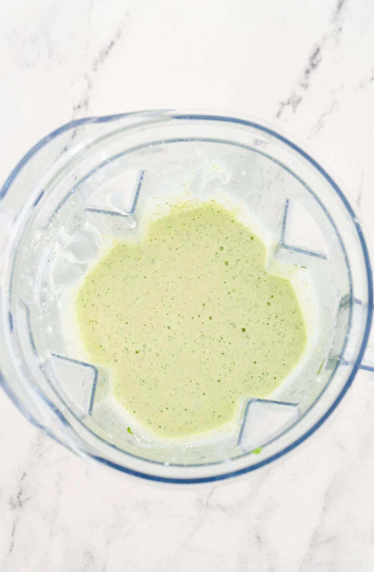 overhead shot of tomatillo dressing in a blender.