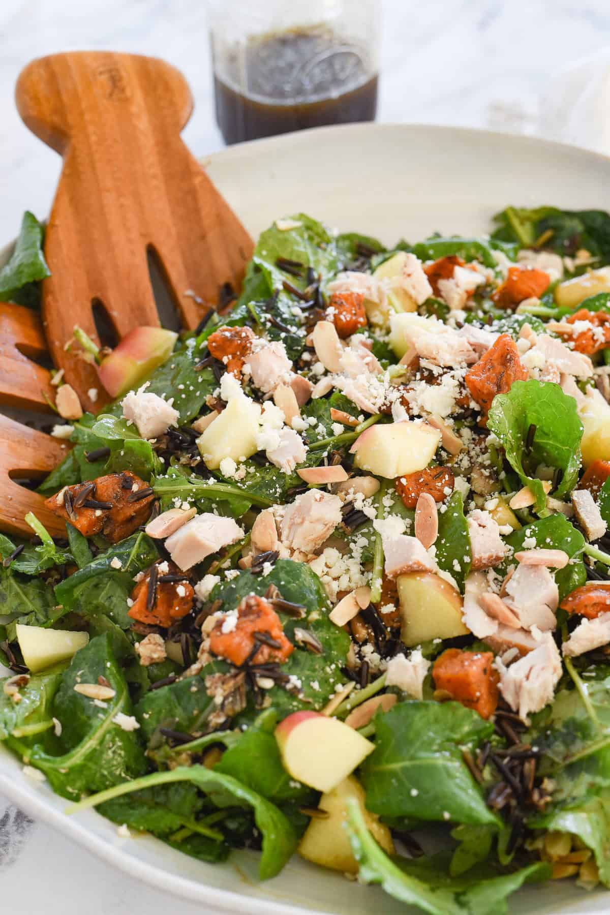 harvest salad in a bowl with salad tongs