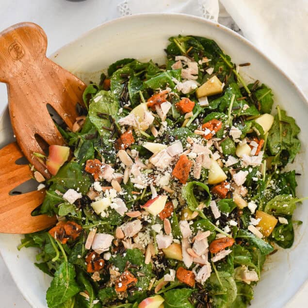 overhead shot of bowl of harvest salad with dressing in a jar