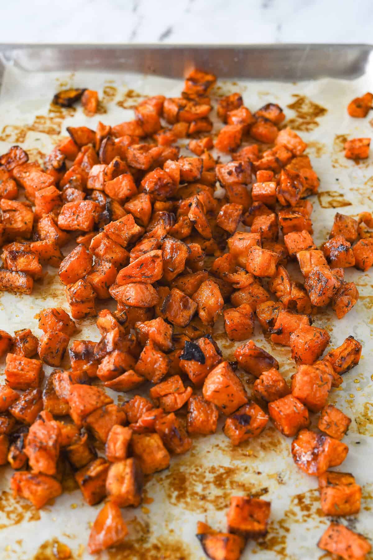 roasted sweet potatoes piled on a baking sheet