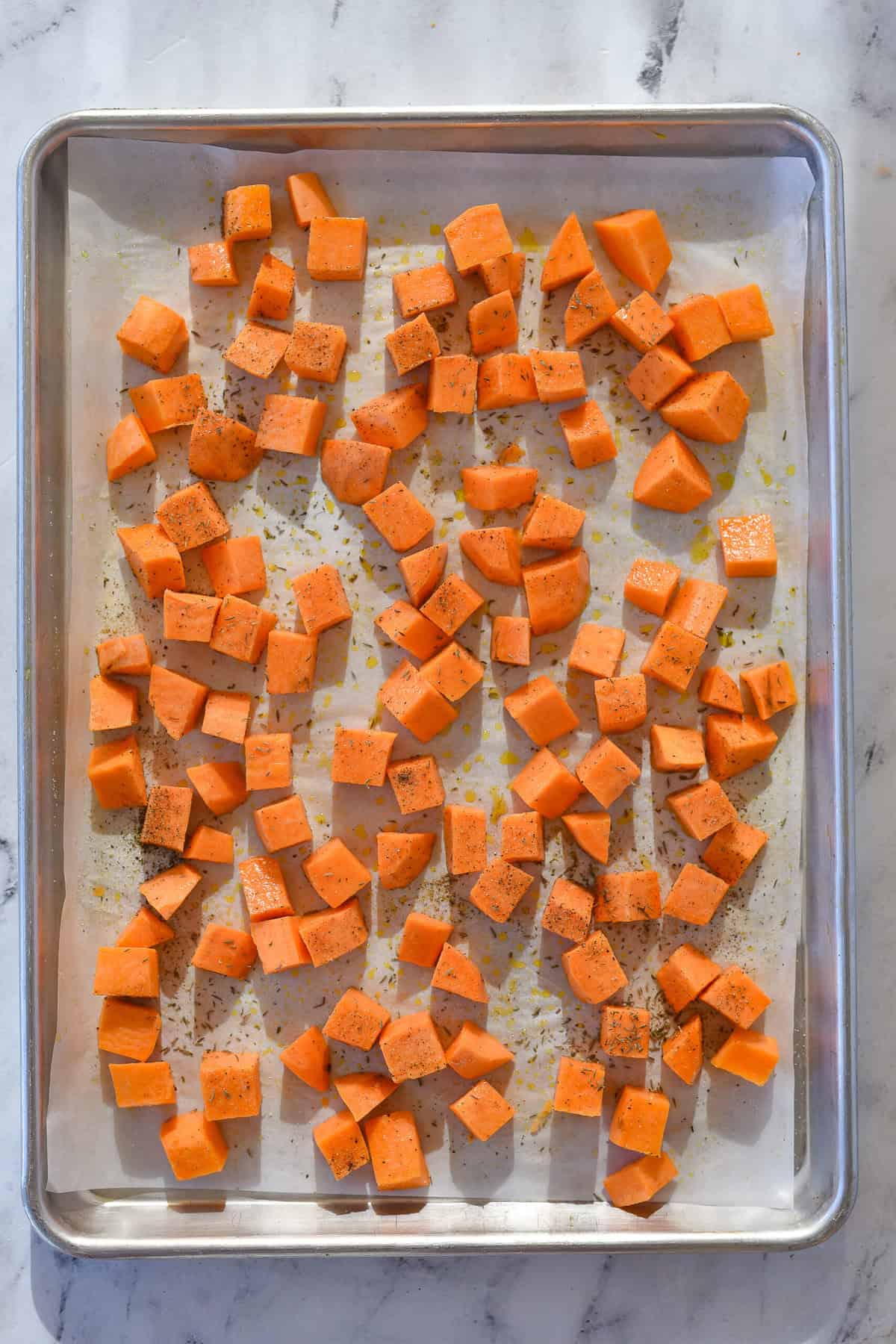 sweet potatoes on parchment paper ready fo roven.