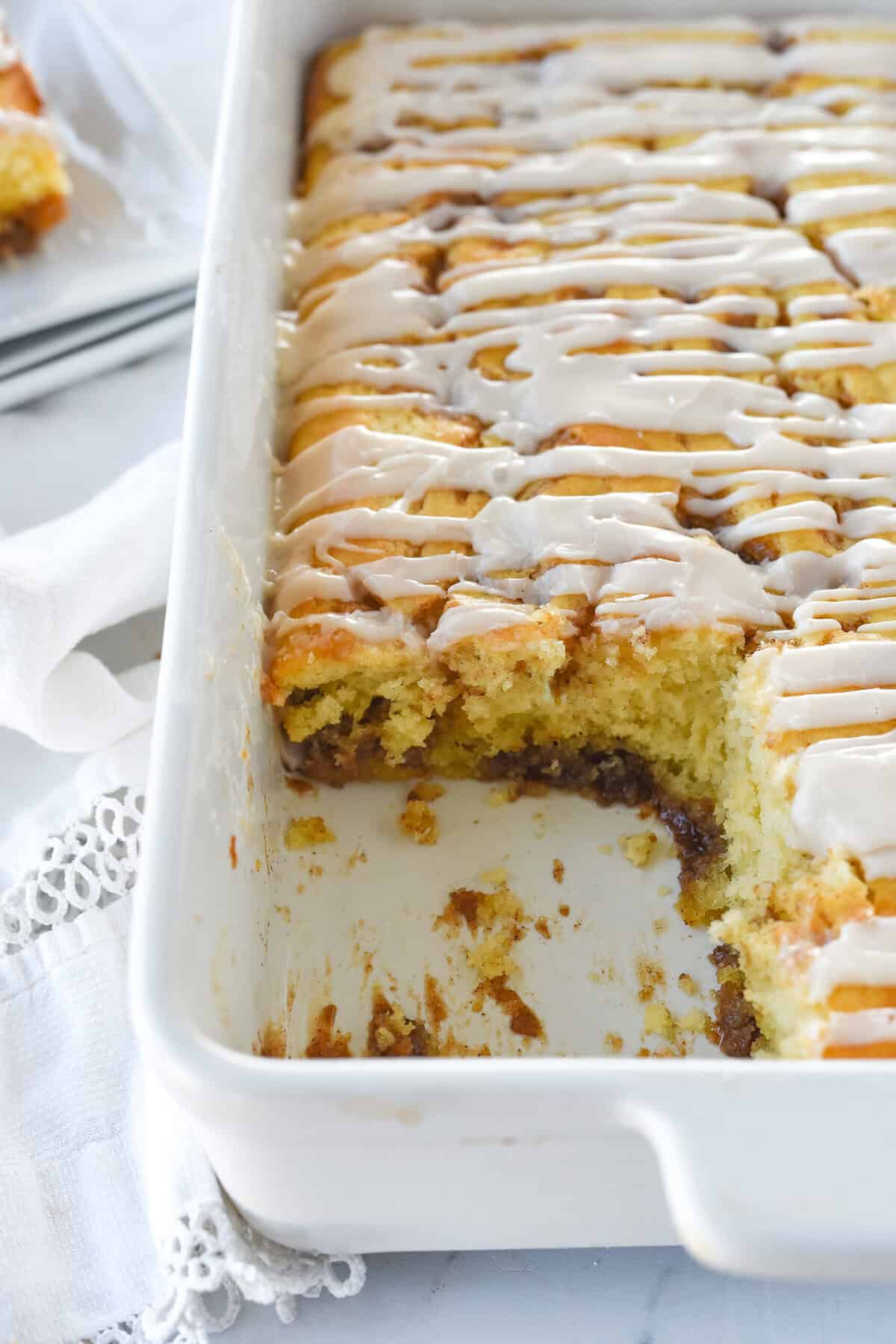pan of cinnamon roll cake with piece missing