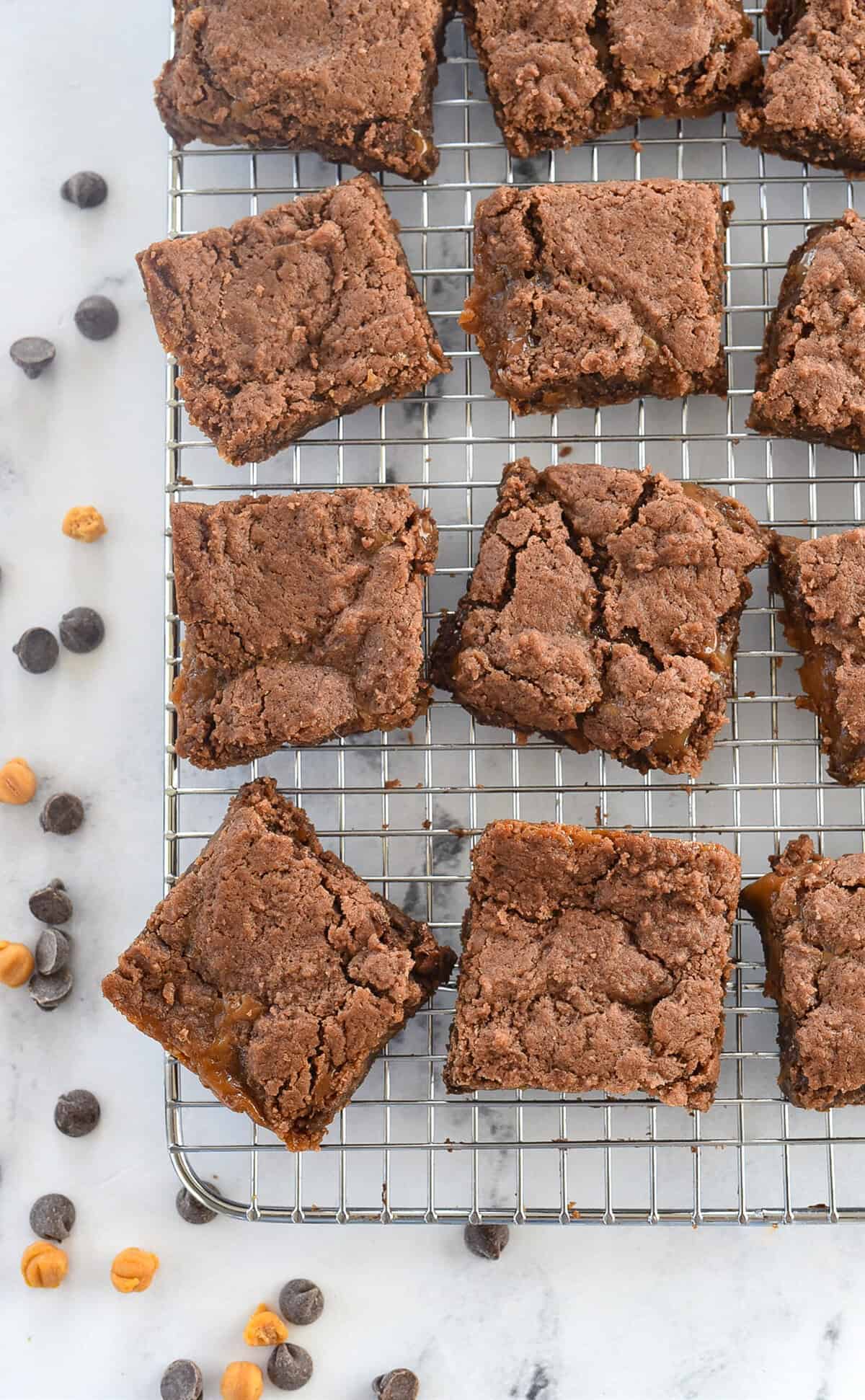 caramel brownie sqauares on a cooling rack
