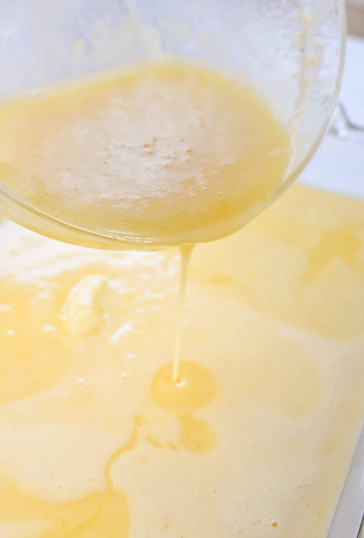 pouring lemon bar mixture over crust