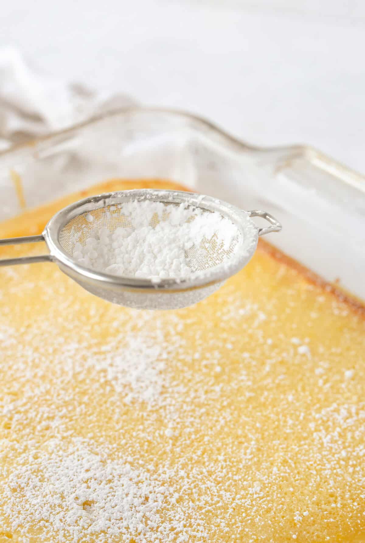 sprinkling powdered sugar over lemon bars