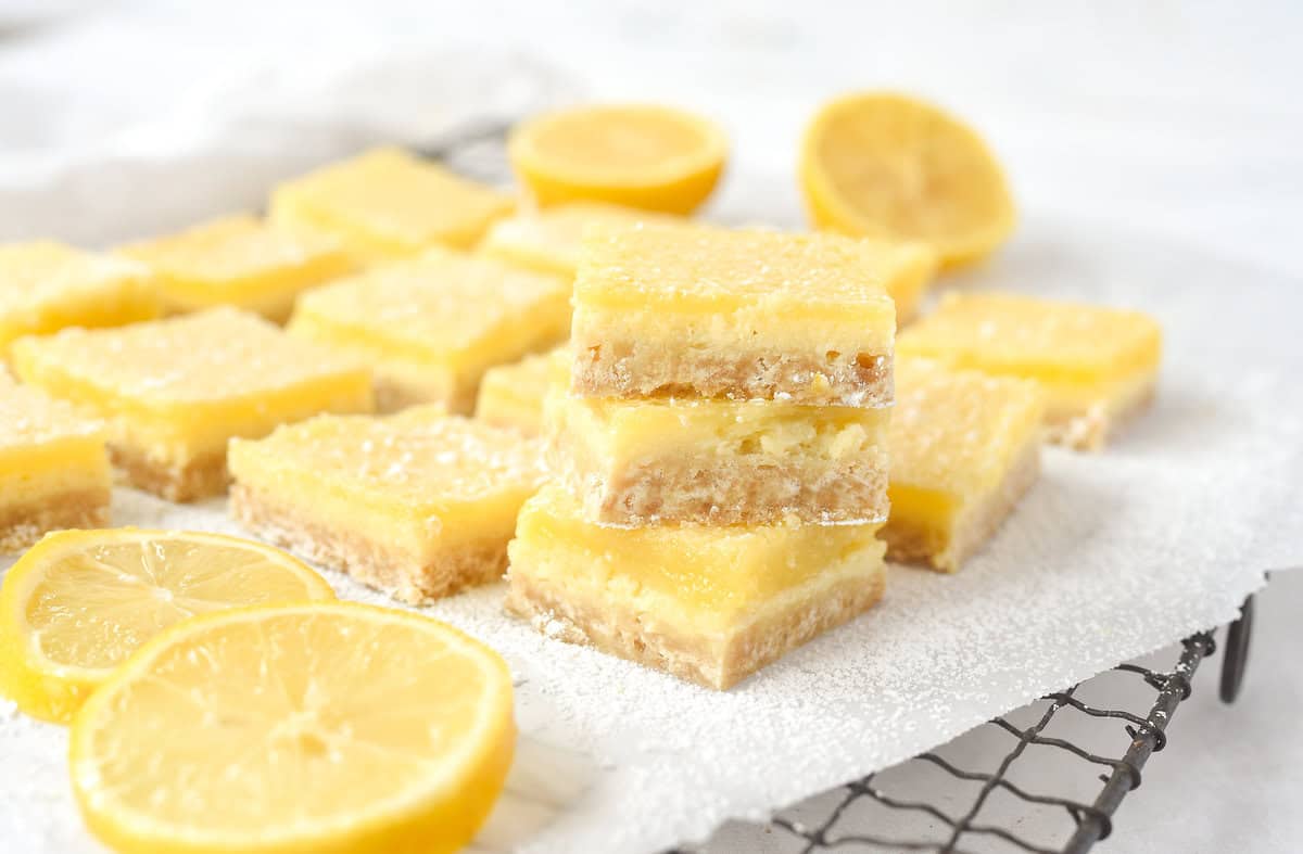 stack of three lemon cheesecake bars on a cooling rack