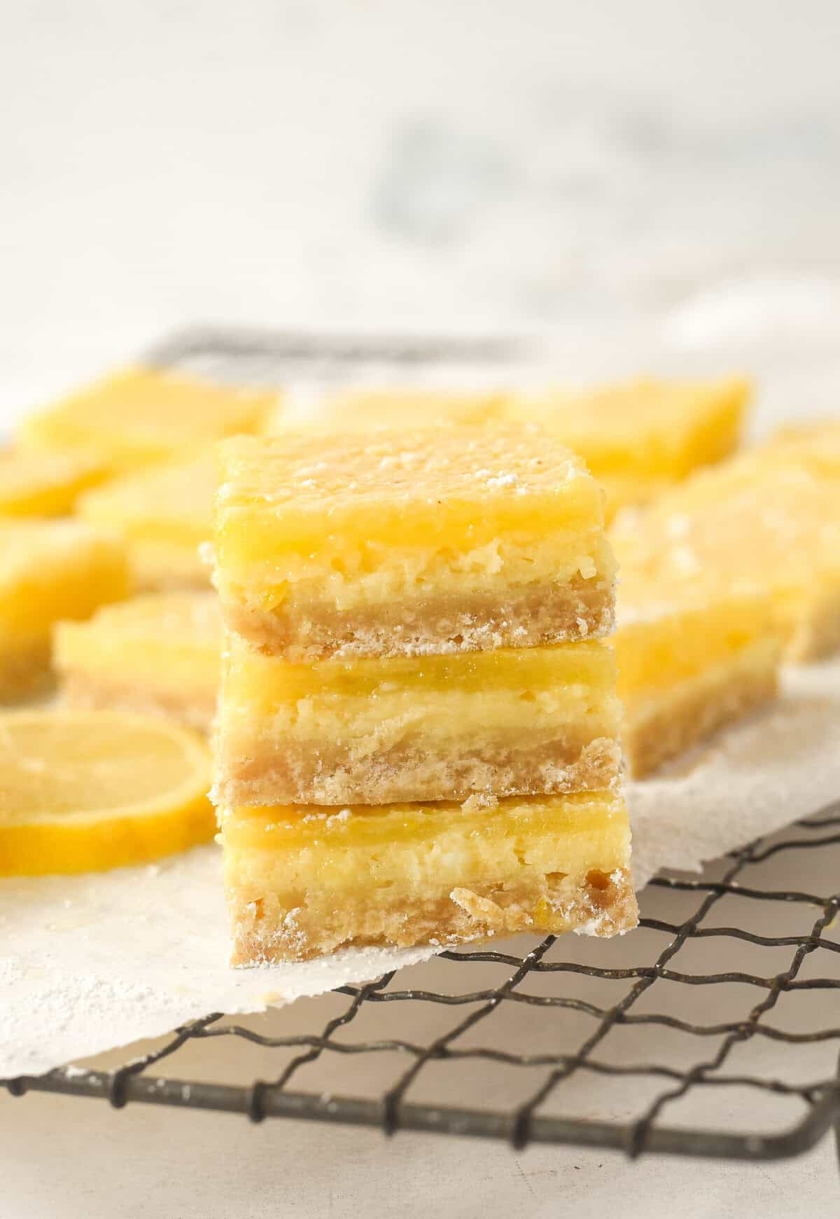 lemon cheesecake bars closeup of a stack of lemon cheesecake bars