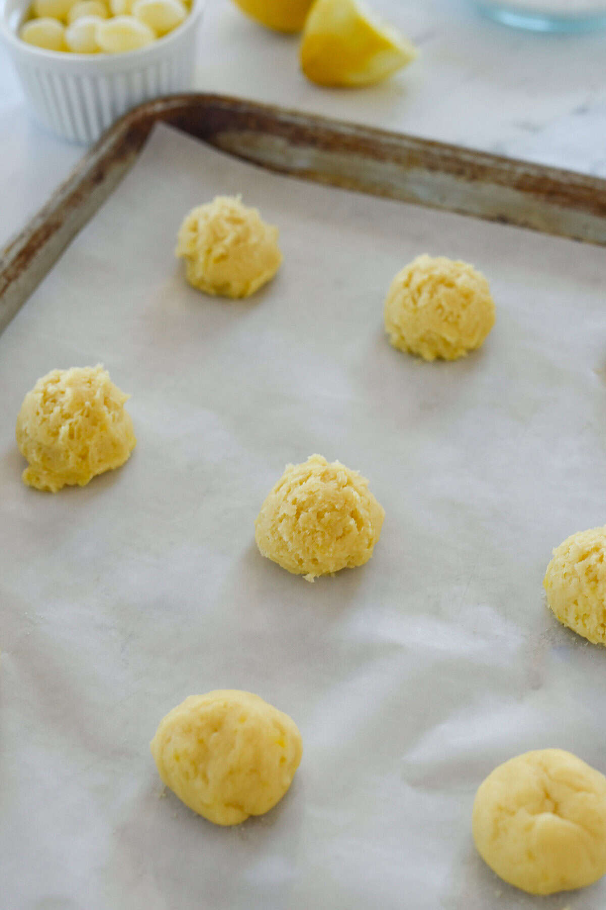 balls of lemon drop cookie dough on baking sheet