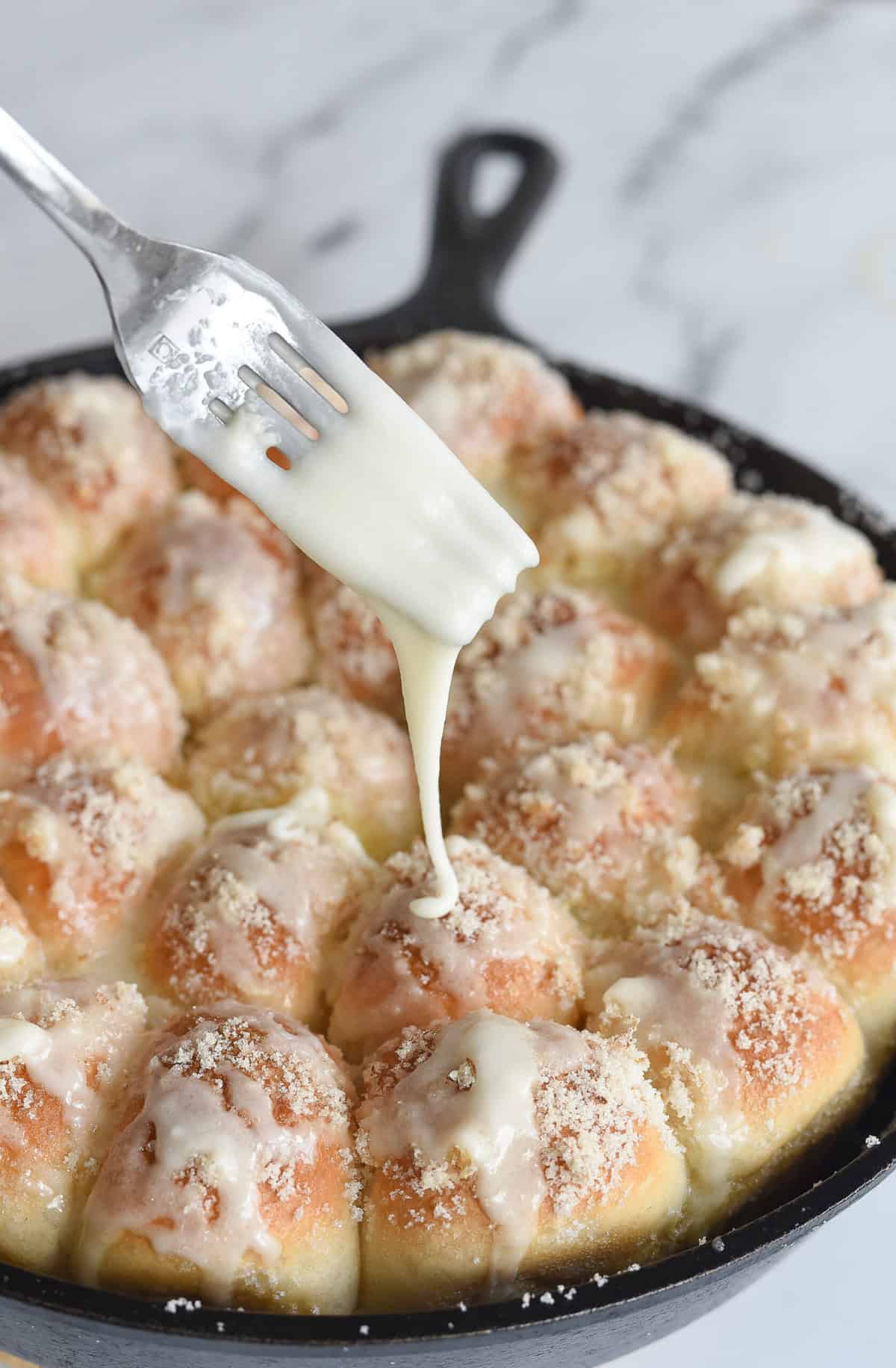 pouring glaze over top of lemon pull apart rolls