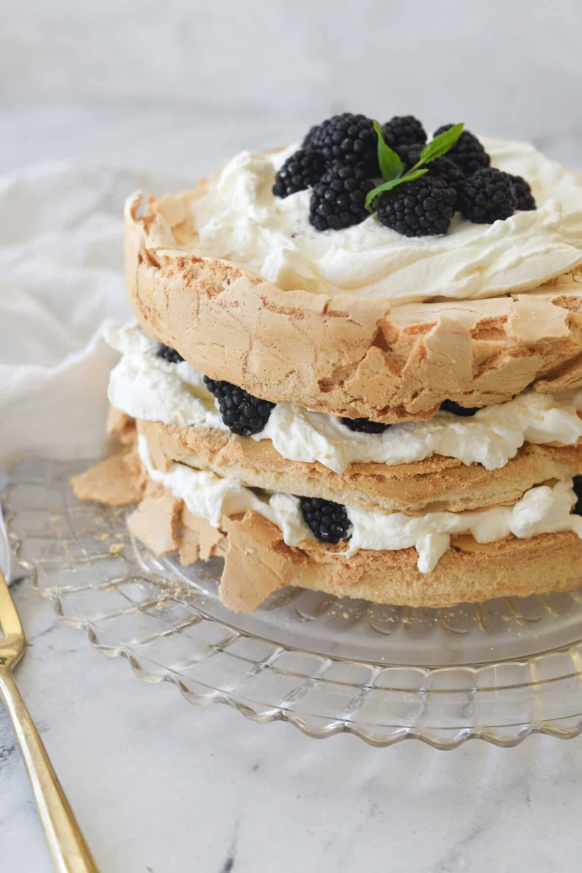 brown sugar pavlova on a plate with blackberries on top