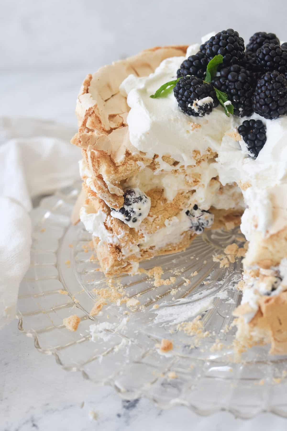 a brown sugar pavlova with a slice missing.