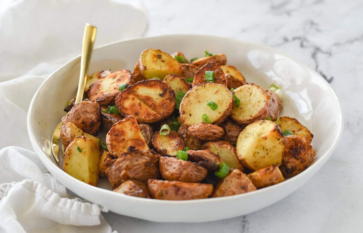 bowl of ranch roasted potatoes with green onions on top