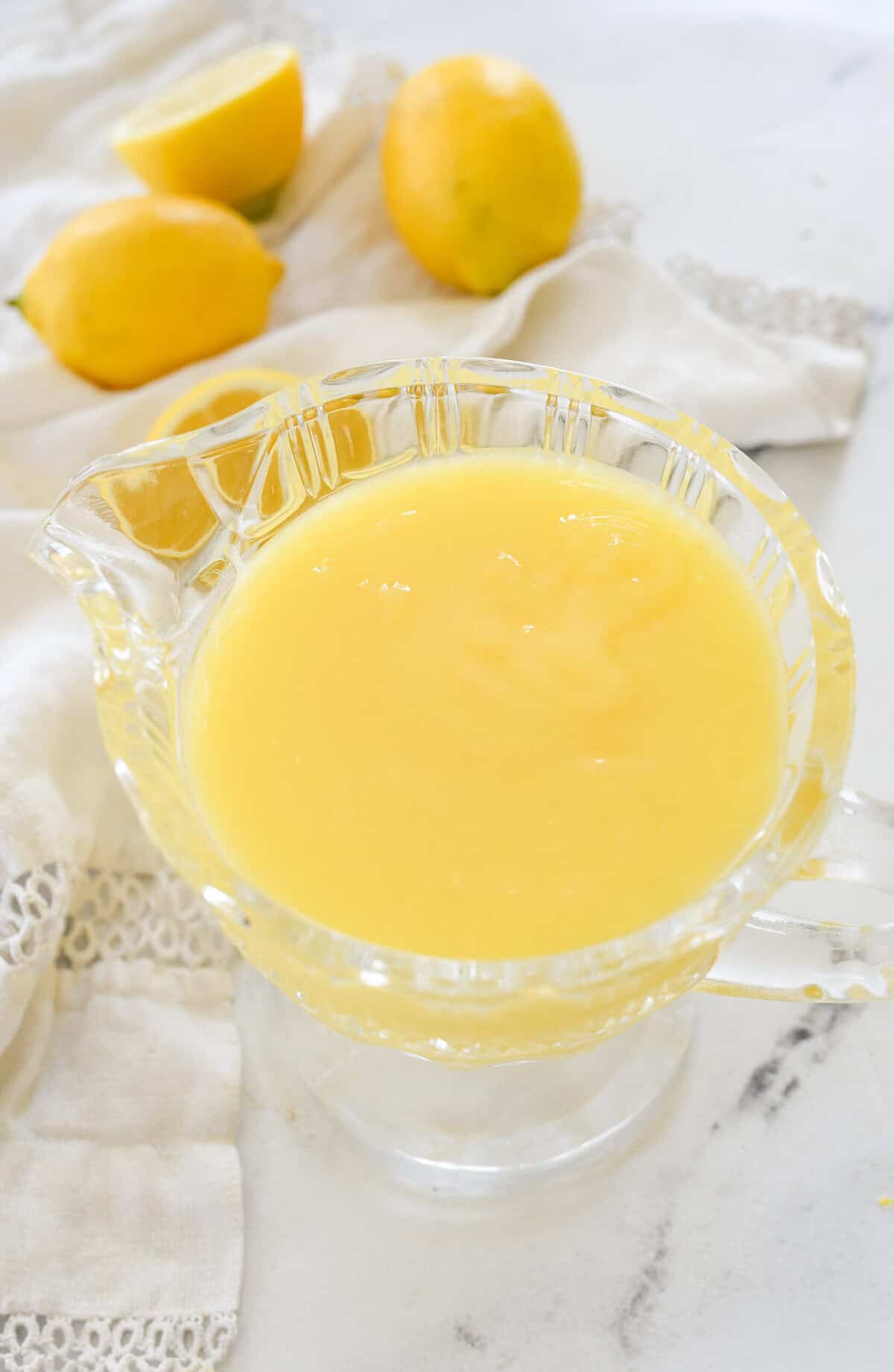 overhead shot of lemon curd in a clear crystal pitcher