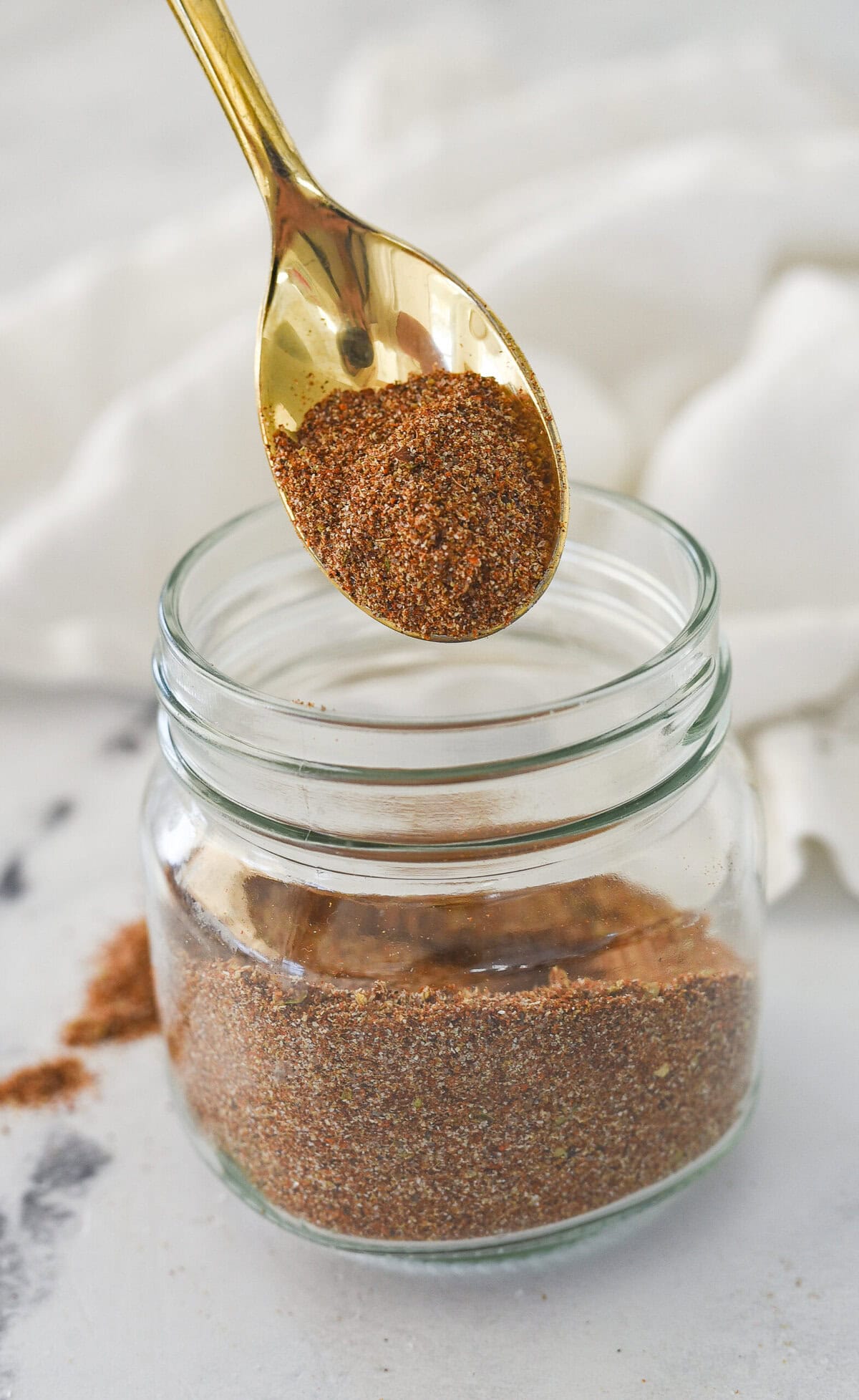 taco seasoning on a spoon and a jar