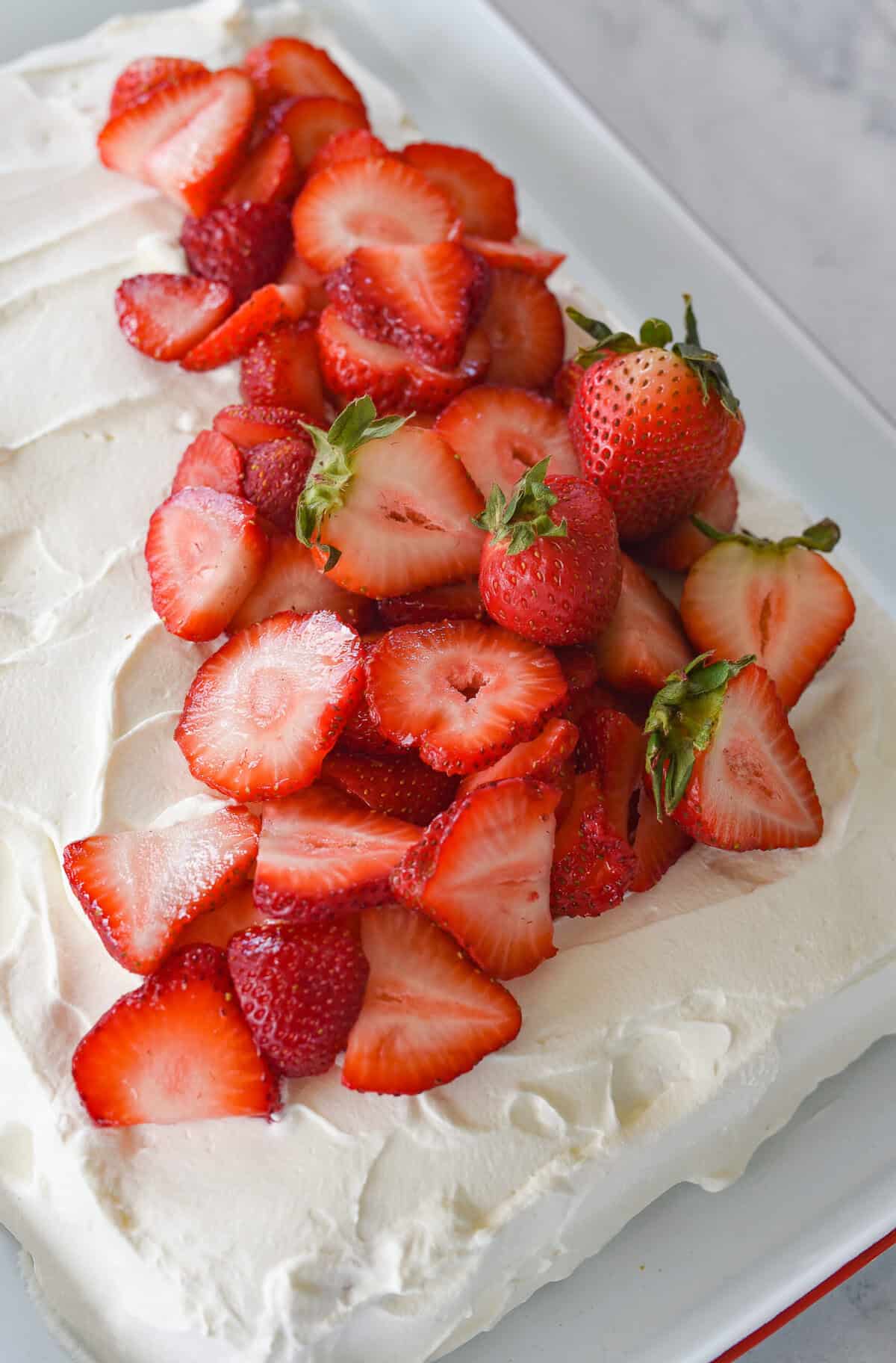 sliced strawberries ontop of tres leches cake