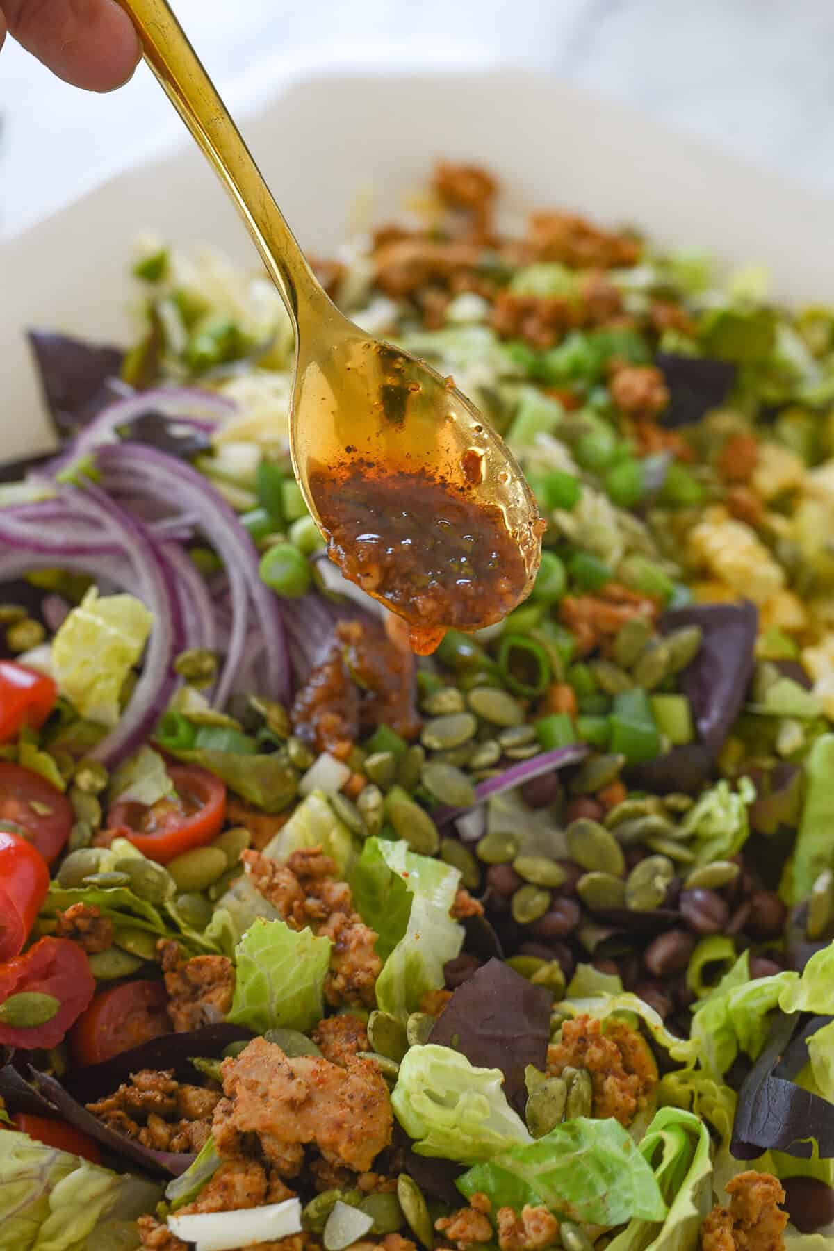 adding salad dressing to chicken taco salad