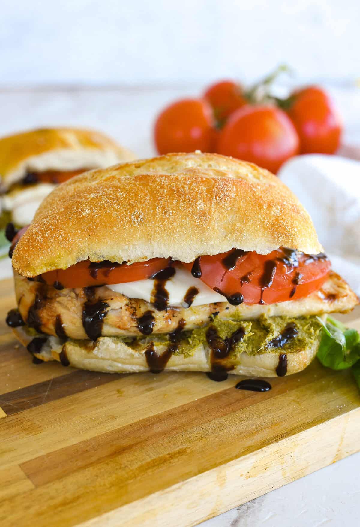a chicken caprese sandisch with balsamic vinegar dripping off of it.