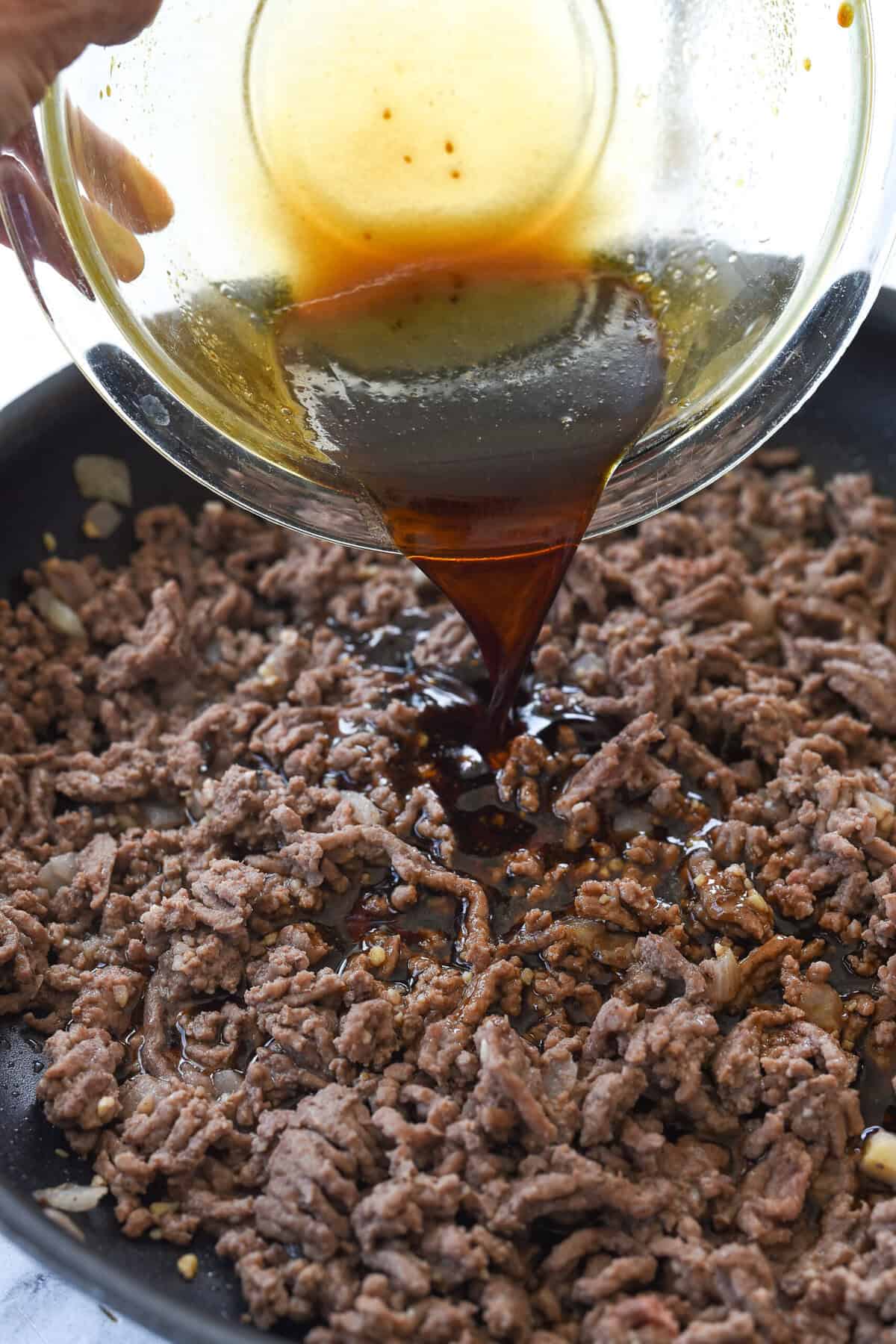 pouring sauce over korean beef
