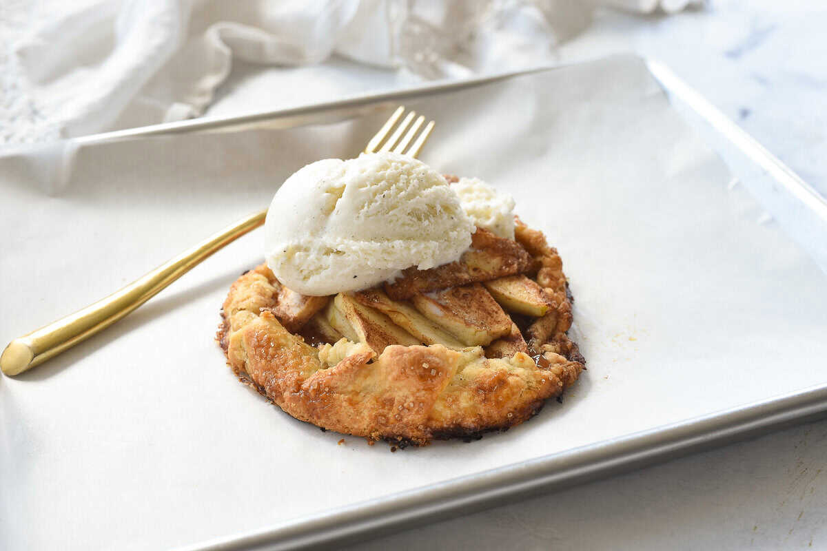 Apple galette with a scoop of ice cream on a tray
