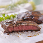 flat iron steak sliced on parchment paper