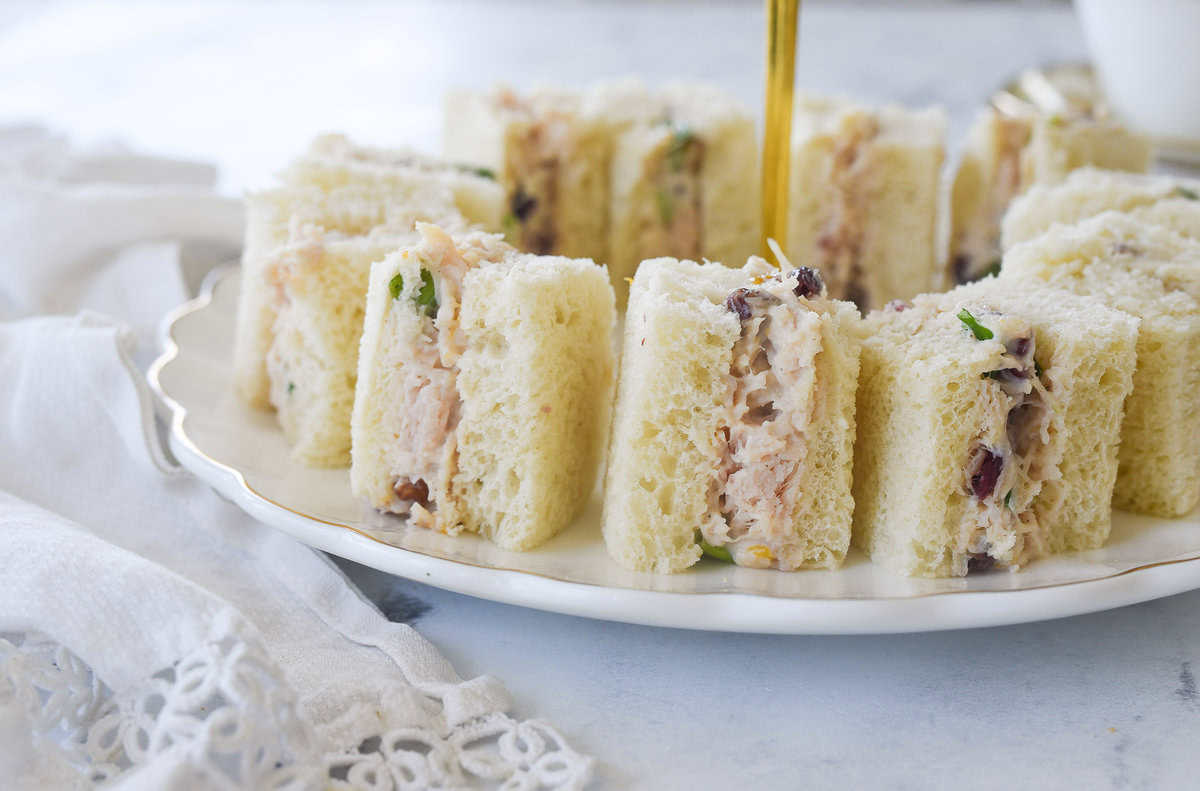 side view of chicken salad tea sandwiches on a plate
