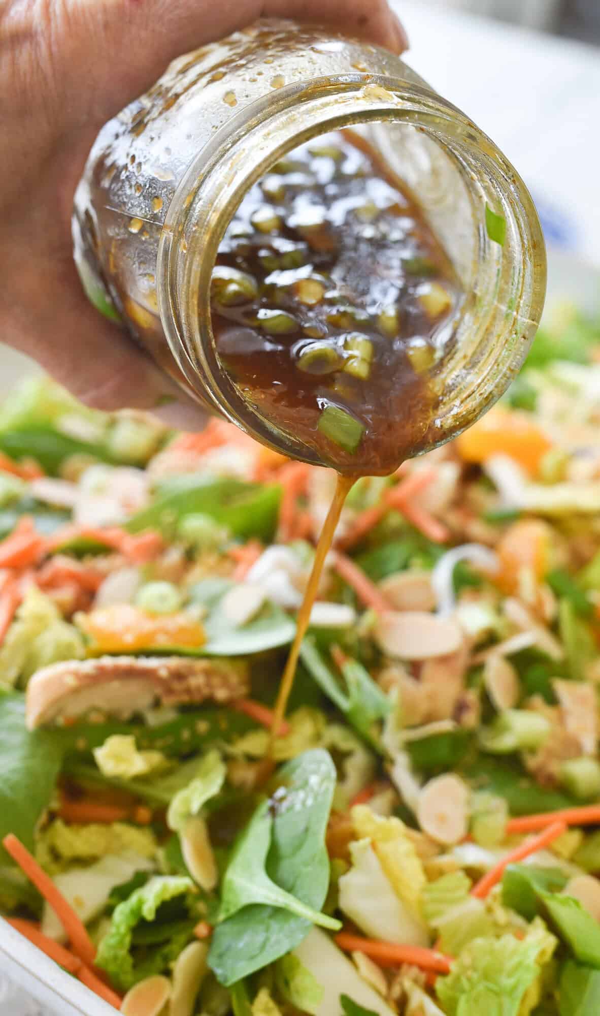 adding dressing to sesame chicken salad