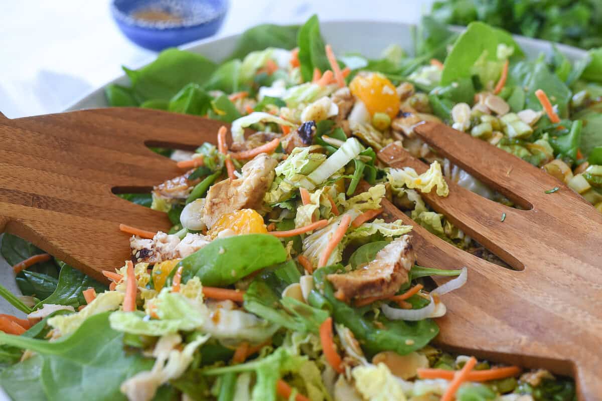 salad tongs scooping up salad in a bowl