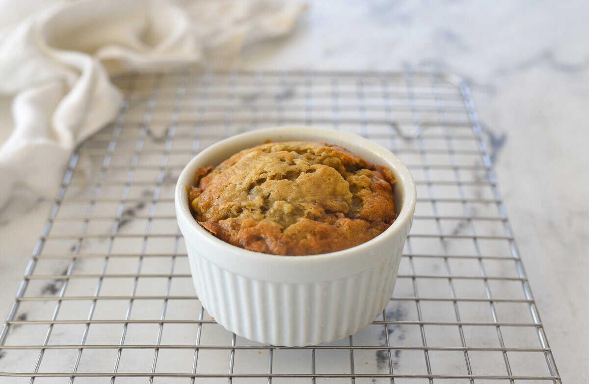 white ramekin of banana bread for one on a cooling rack
