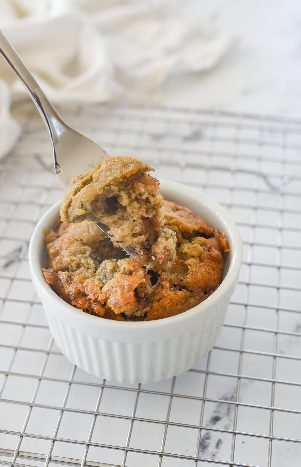 fork full of banana bread for one in a white ramekin
