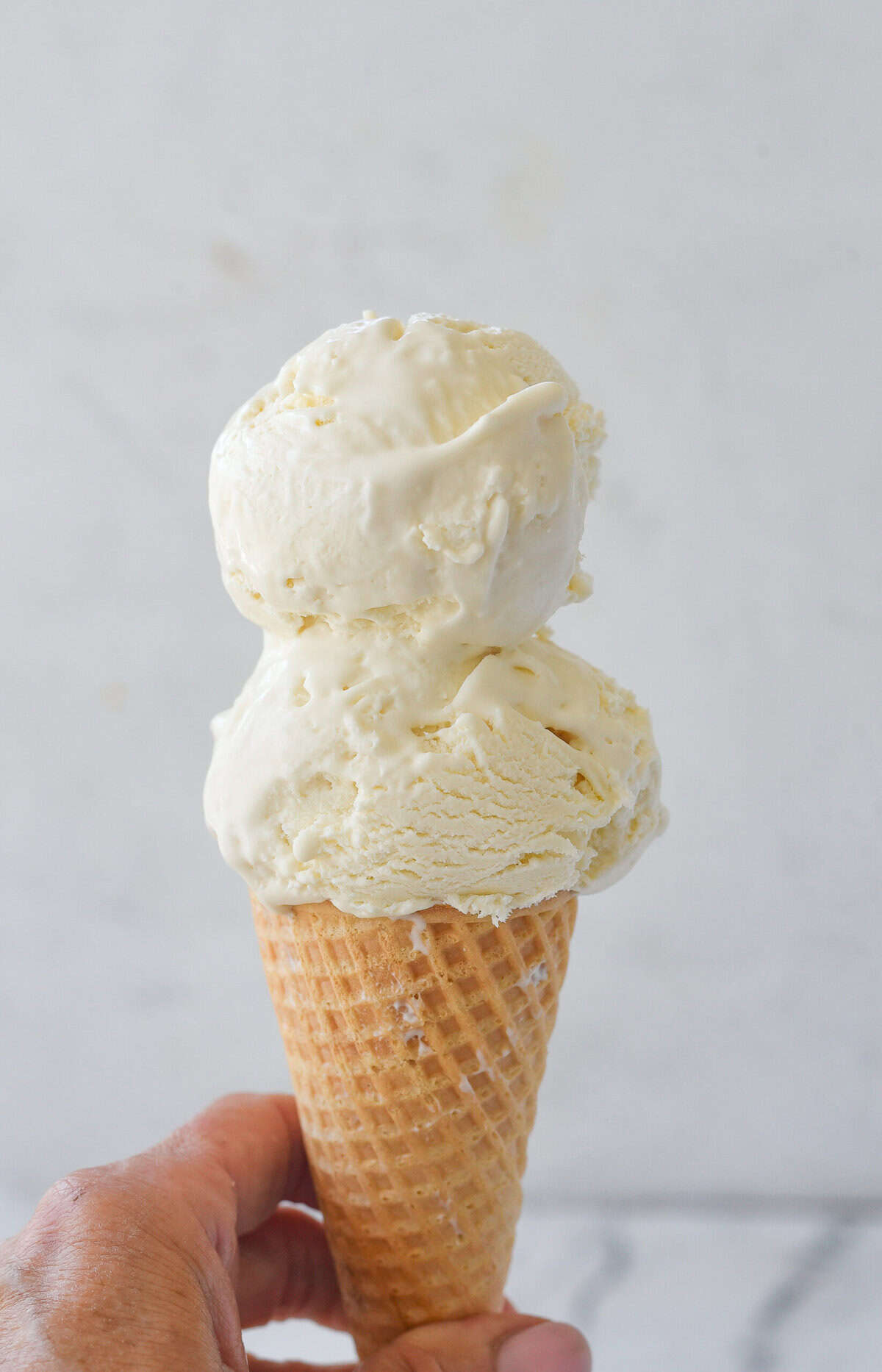 hand holding a vanilla ice cream cone