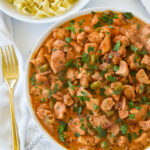 overhead shot of chicken paprikish in a white bowl