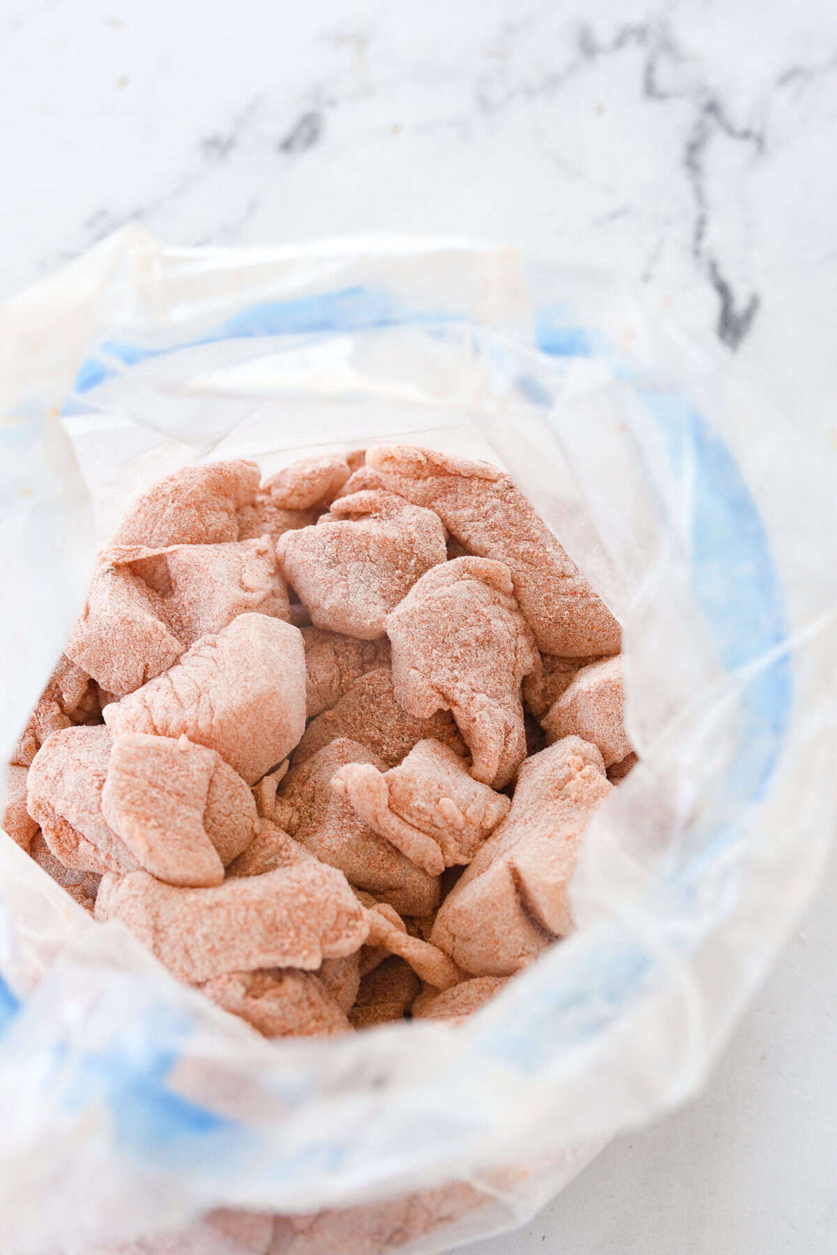 chicken coated in flour in a bag