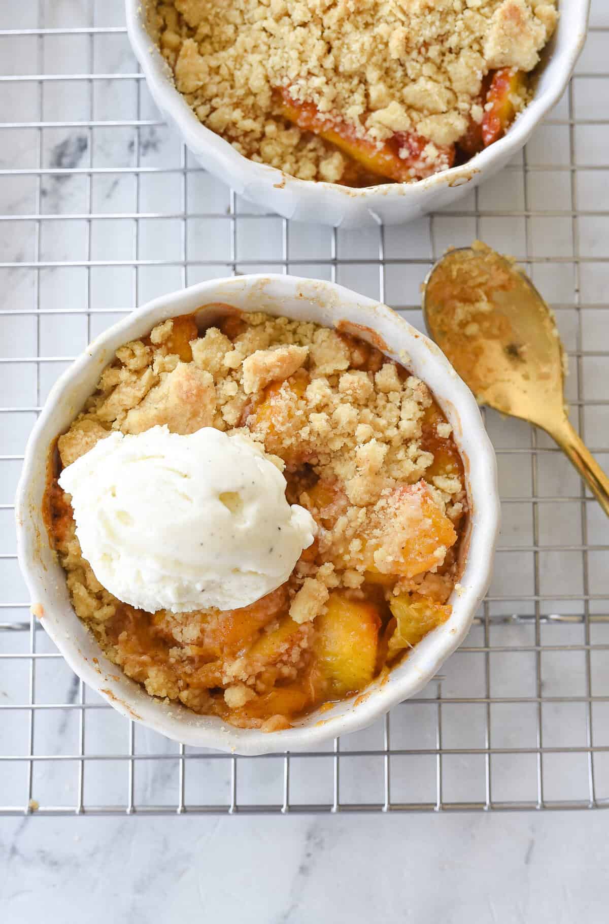 scoop of vanilla ice cream on top of peach cobbler for two