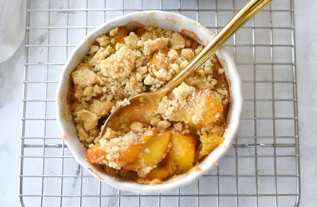 overhead shot of peach cobbler with a spoon in it