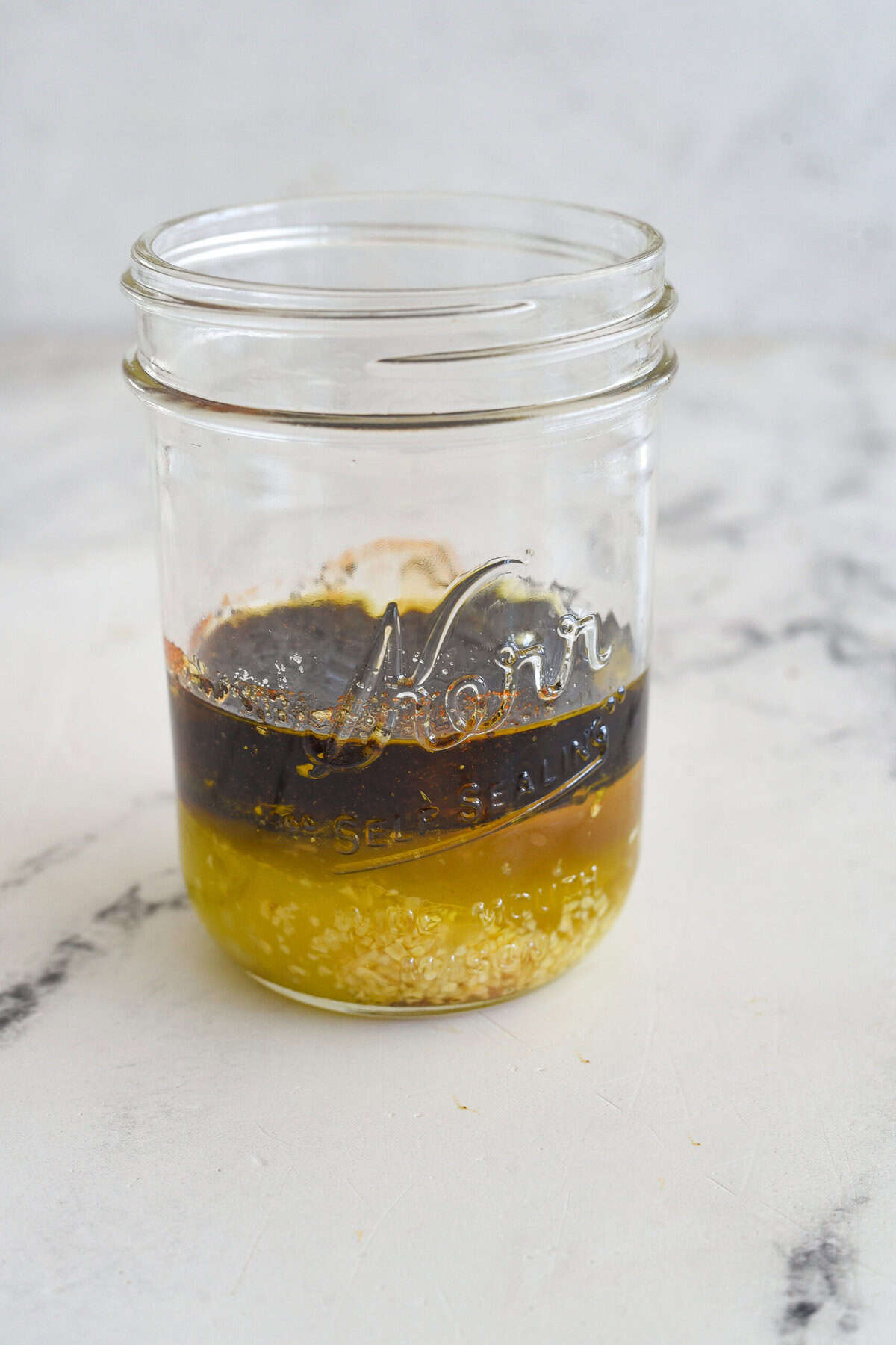 poppy seed dressing ingredients layered in a jar.