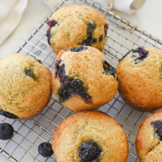 pile of blueberry freezer muffins on a cooling rack