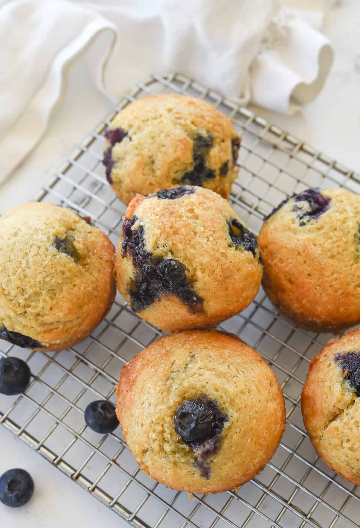 pile of blueberry freezer muffins on a cooling rack