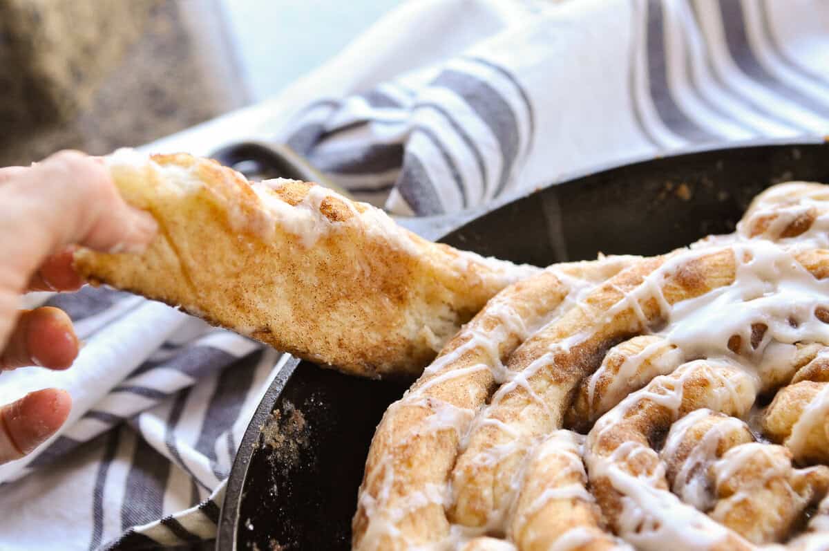 hand pulling apart a skillet cinnamon roll