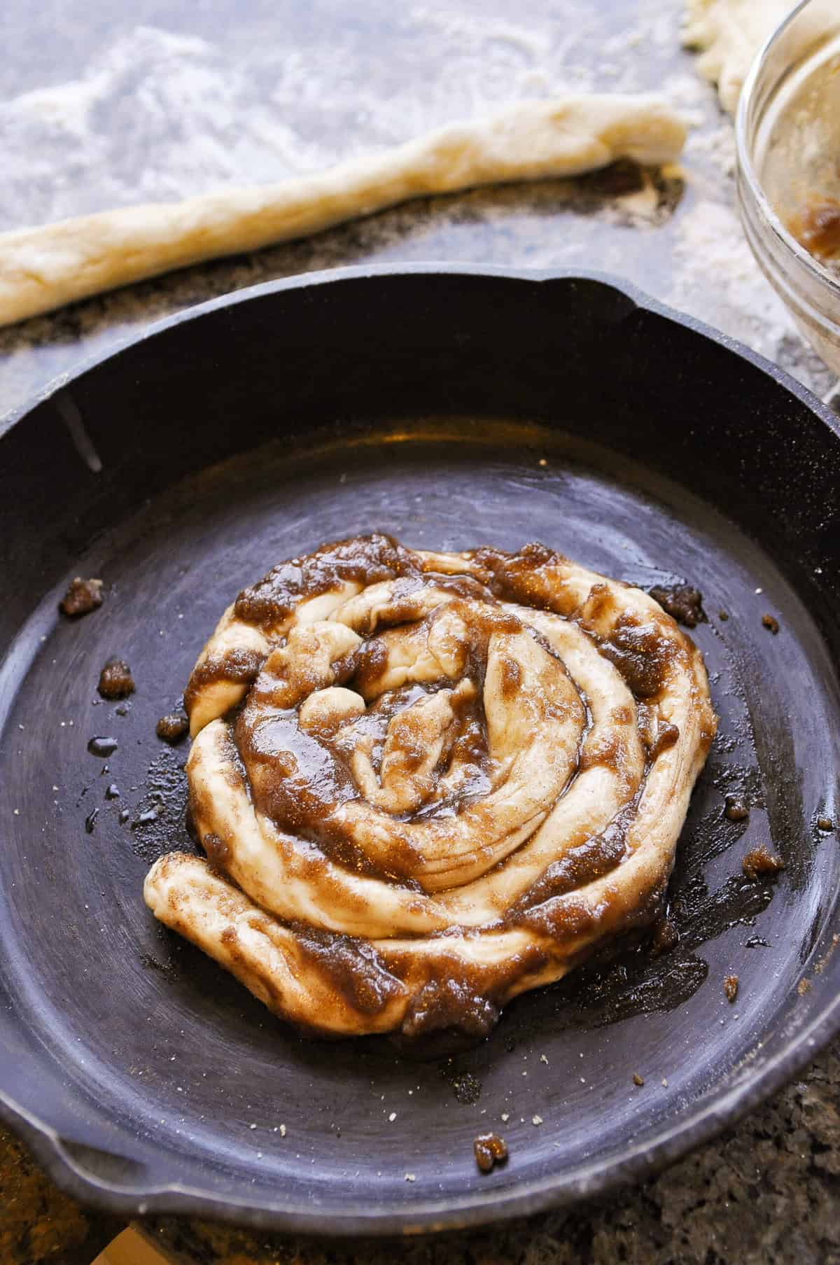 rolling up a skillet cinnamon roll