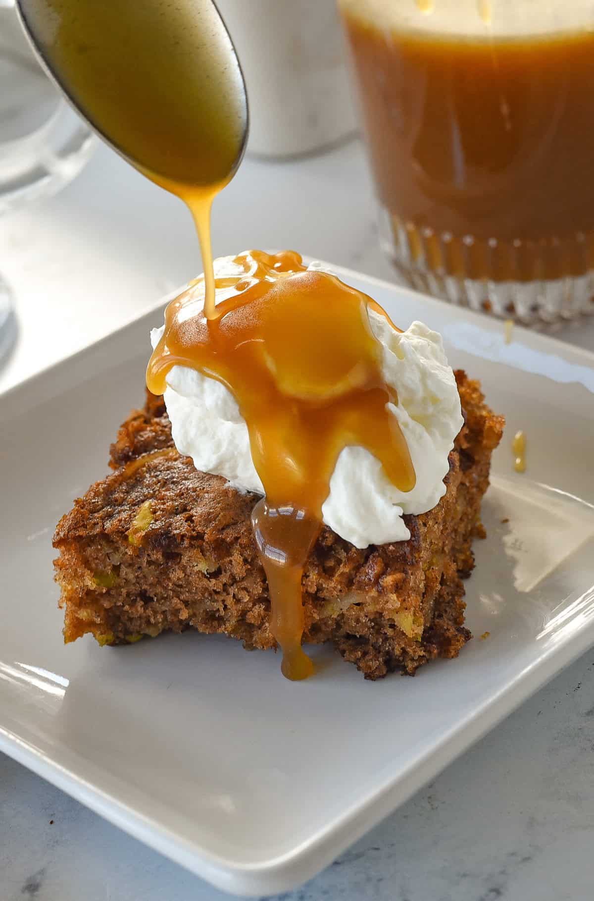 pouring caramel sauce over apple cake
